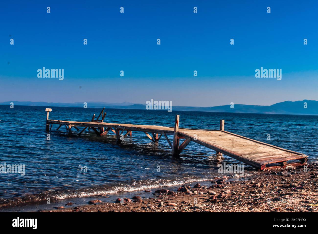 Cunda, Balikesir, Türkei - Juli 2022: Hölzerner Pier, der sich bis zum Meer auf der Halbinsel Cunda erstreckt, selektiver Fokus Stockfoto