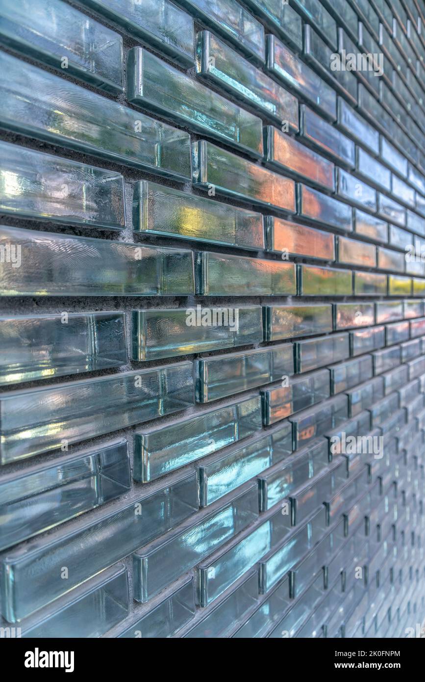 Austin, Texas – Nahaufnahme einer Gebäudewand mit Glasziegeln in einem verlaufenden Bindungsmuster. Außenansicht des Gebäudes mit reflektierender Glaswand. Stockfoto