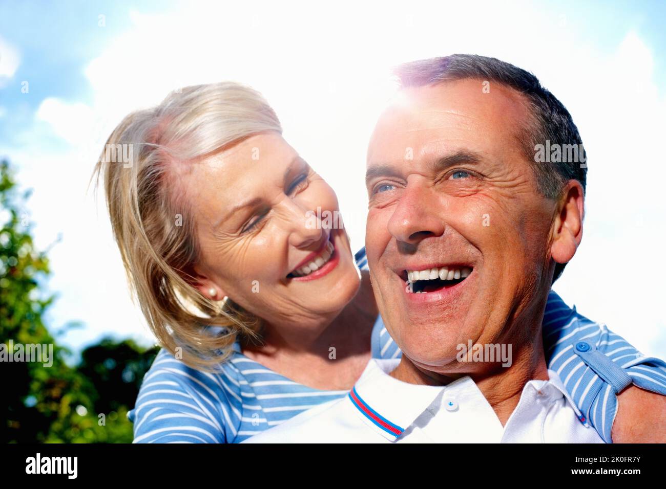 Fröhlicher Mann und Frau verbringen gemeinsam Zeit gegen den Himmel. Nahaufnahme Porträt eines fröhlichen älteren Mannes und einer Frau, die gemeinsam Zeit gegen den Himmel verbringen. Stockfoto