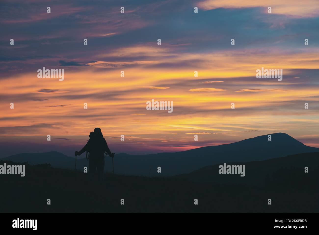 Wanderer mit Wanderstöcken auf dem Berggipfel genießen die Aussicht. Stockfoto