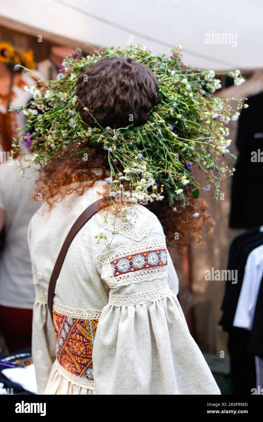 Defocus schönes Mädchen in Kranz von Blumen und ukrainische Stickerei. Porträt einer jungen schönen Frau, die einen Kranz aus wilden Blumen trägt. Junge Slawistik Stockfoto