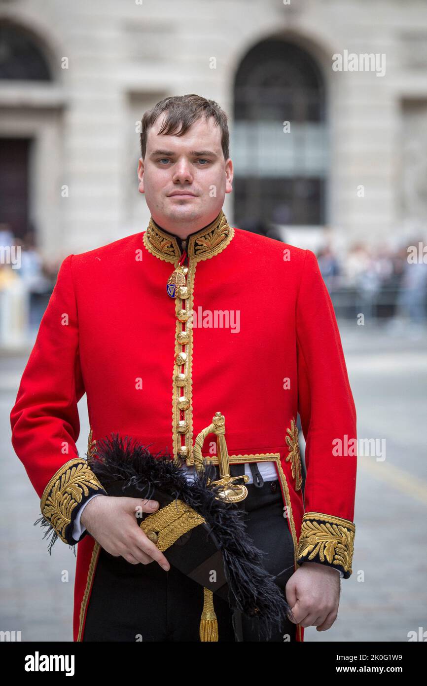 Rüde mit rotem Mantel, Uniform der britischen Armee, die vor der Royal Exchange in der City of London, Großbritannien, steht Stockfoto