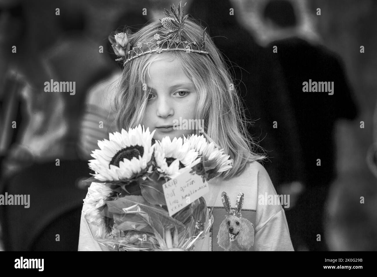 London UK 10. September 2022 - Ein junges Mädchen bringt Blumen mit Botschaft, RIP Unsere Königin - Trauernde versammeln sich am Buckingham Palace und platzieren Blumen.UK Stockfoto