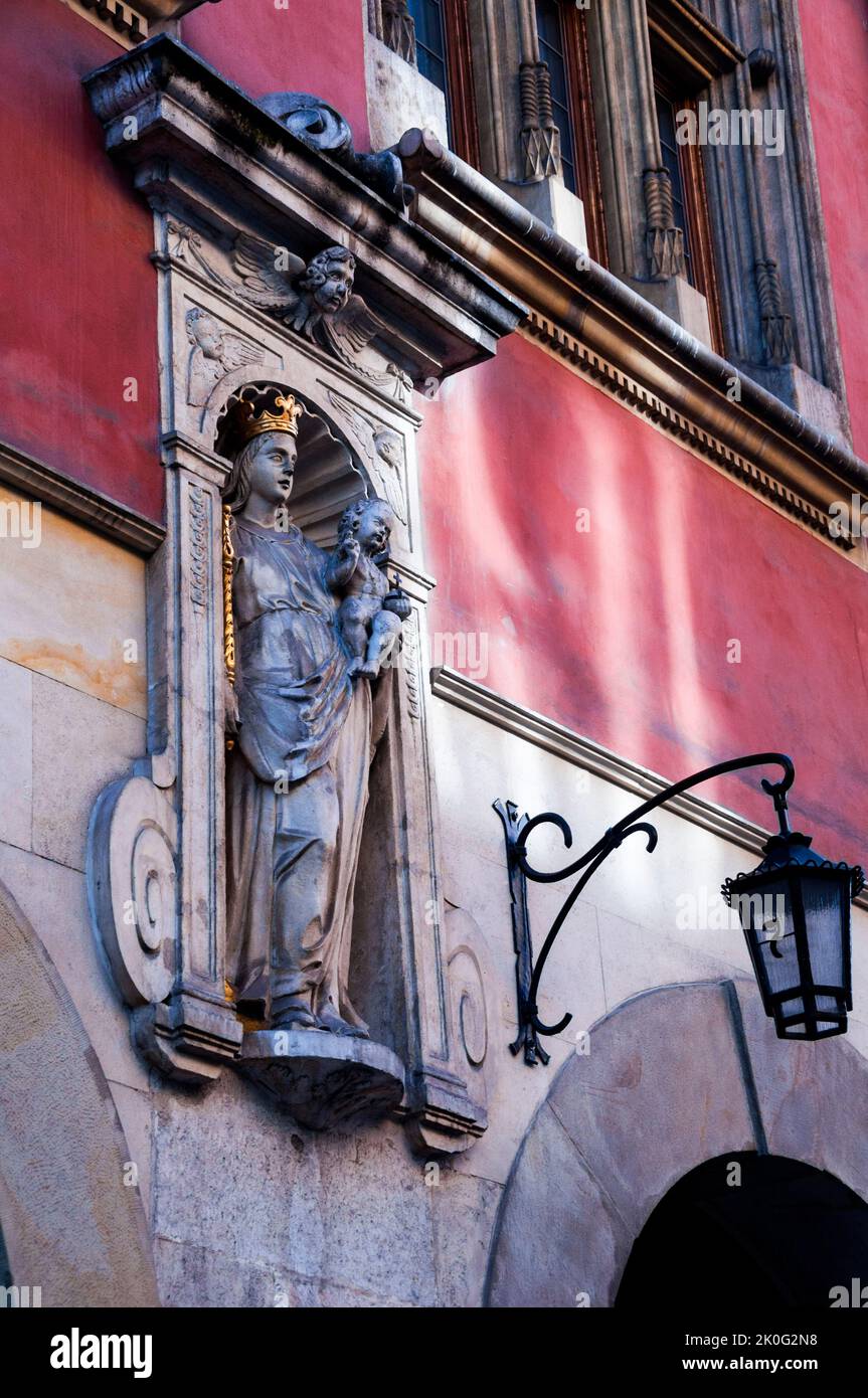 Architektonische Nische mit einer Statue von Maria, die ein Zepter hält und dem Jesuskind, das ein Kreuz hält, und einer alten Lampe mit der Hausnummer 7 in Krakau, Polen. Stockfoto