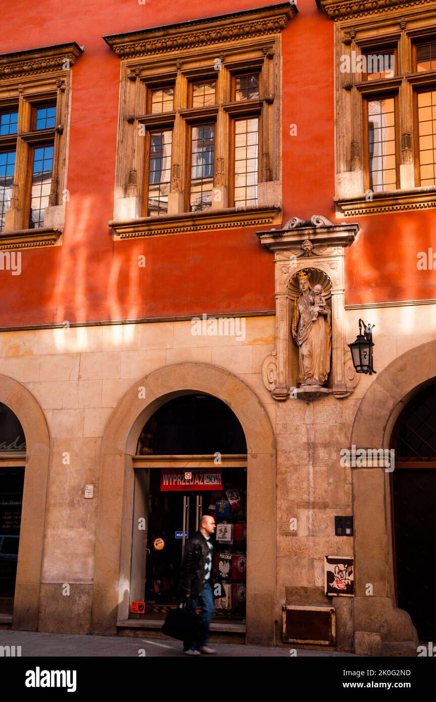 Architektonische Nische mit einer Statue von Maria, die ein Zepter hält und dem Jesuskind, das ein Kreuz hält, und einer alten Lampe mit der Hausnummer 7 in Krakau, Polen. Stockfoto