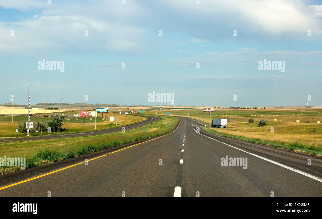 Mitten auf der Straße mit Striche in der Mitte auf der Interstate Highway 94, die an einem Sommerabend im Westen von North Dakota wenig bis gar keinen Verkehr zeigen Stockfoto