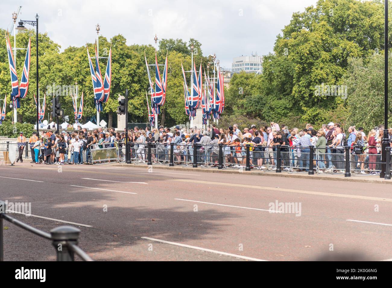 Menschen, die geduldig in einer langen Schlange stehen, um am Buckingham Palace Respekt zu zollen Stockfoto