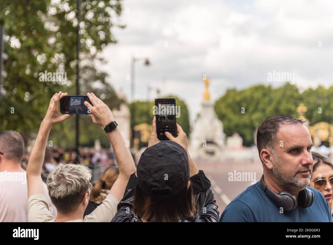 Menschen, die Fotos vom Buckingham Palace machen, stehen Schlange Stockfoto