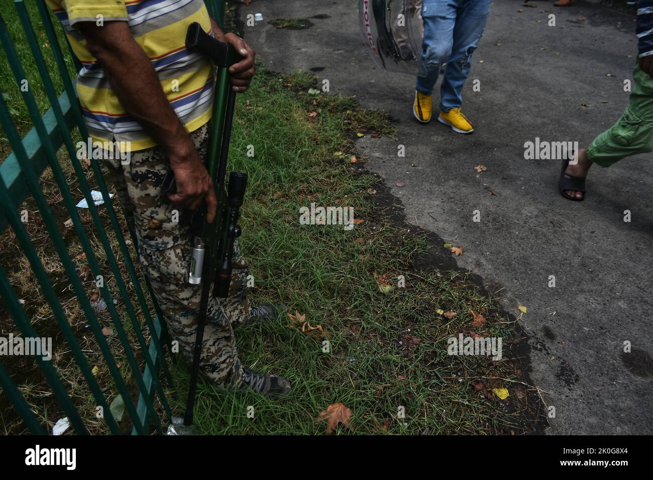 11. September 2022, Srinagar, Jammu and Kashmir, Indien: Wildtierbeamter versteckt sich in der Nähe des Zauns, während er während der Suche nach einem wilden Bären ein Beruhigungsmittel mit einer Dartpistole in Richtung eines verdächtigen Ortes hält, nachdem ein Zivilist bei seinem Angriff in Srinagar, dem von Indien kontrollierten Kaschmir, am Sonntag, dem 11. September 2022 verletzt wurde. (Bild: © Mubashir Hassan/Pacific Press via ZUMA Press Wire) Stockfoto