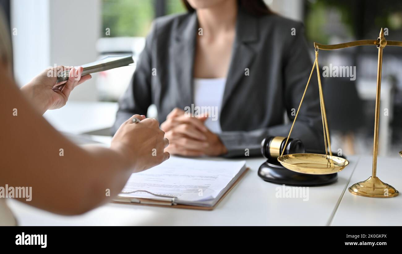 Eine Klientin versucht, ihrem persönlichen Anwalt Bestechung zu gewähren, um eine Klage zu gewinnen. Korruptionskonzept. Freigestellte und Nahaufnahme Hände Bild Stockfoto