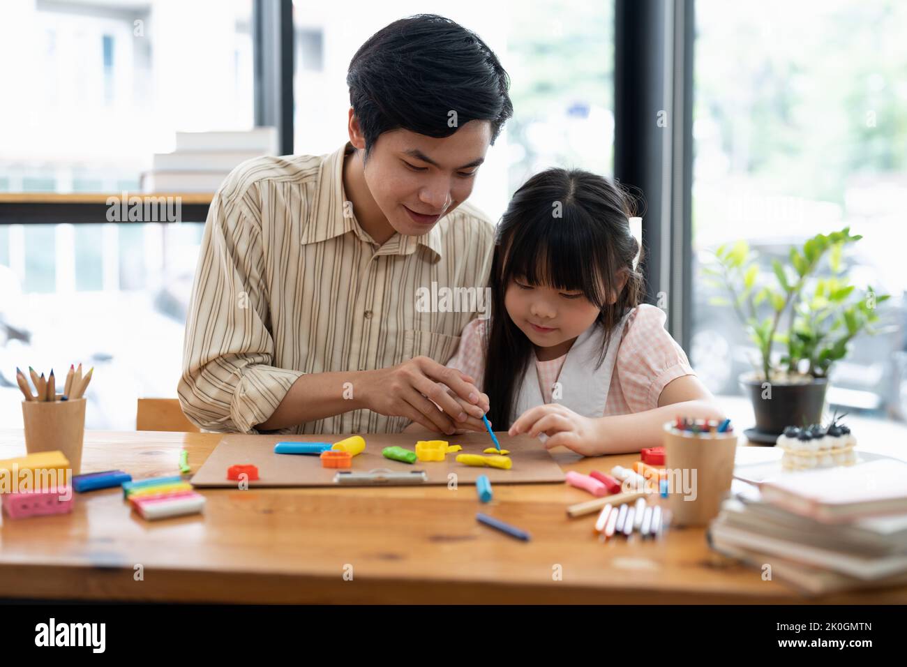 Junge asiatische Vater und Tochter Plastilin oder spielen Teig auf einem Tisch Teig zusammen Stockfoto