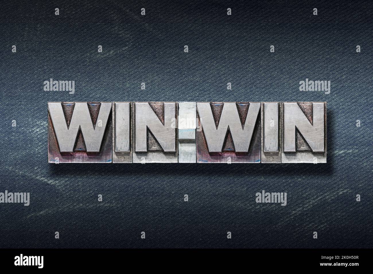 Win-Win-Wort aus Metallic-Buchdruck auf dunklem Jeans-Hintergrund Stockfoto