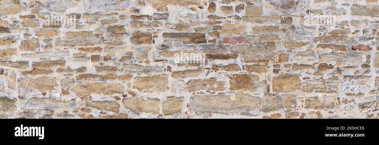 Alte grau-braune Wand aus verschiedenen Natursteinen Stockfoto