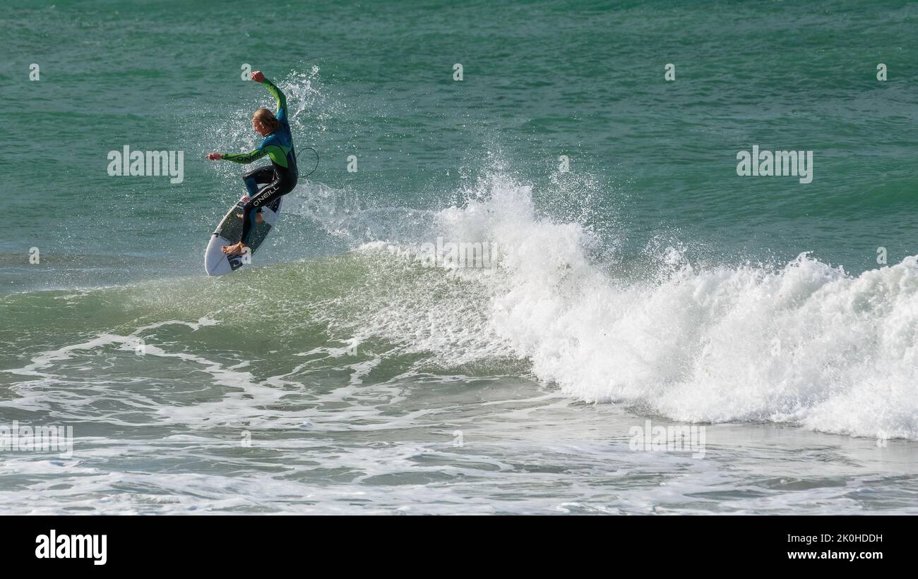 Ein Surfer, der sich von einer brechenden Welle in die Luft schob. Mount Maunganui, Neuseeland Stockfoto