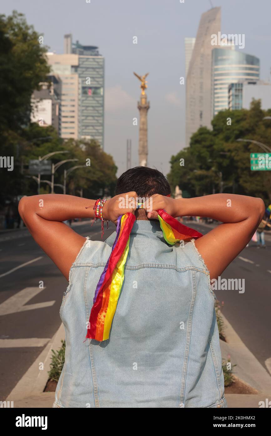 Ein Vertikal eines hispanischen Mannes von hinten gesehen, der ein Kopftuch als Unterstützung am Pride Day in Mexiko-Stadt bindet Stockfoto