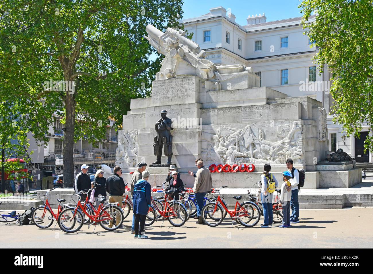 Tourguide bei geführter Führung Gruppe von Frauen und Männern, die sich Fahrräder ausgeliehen haben, um das Royal Artillery Memorial Hyde Park Corner London England zu besichtigen Stockfoto