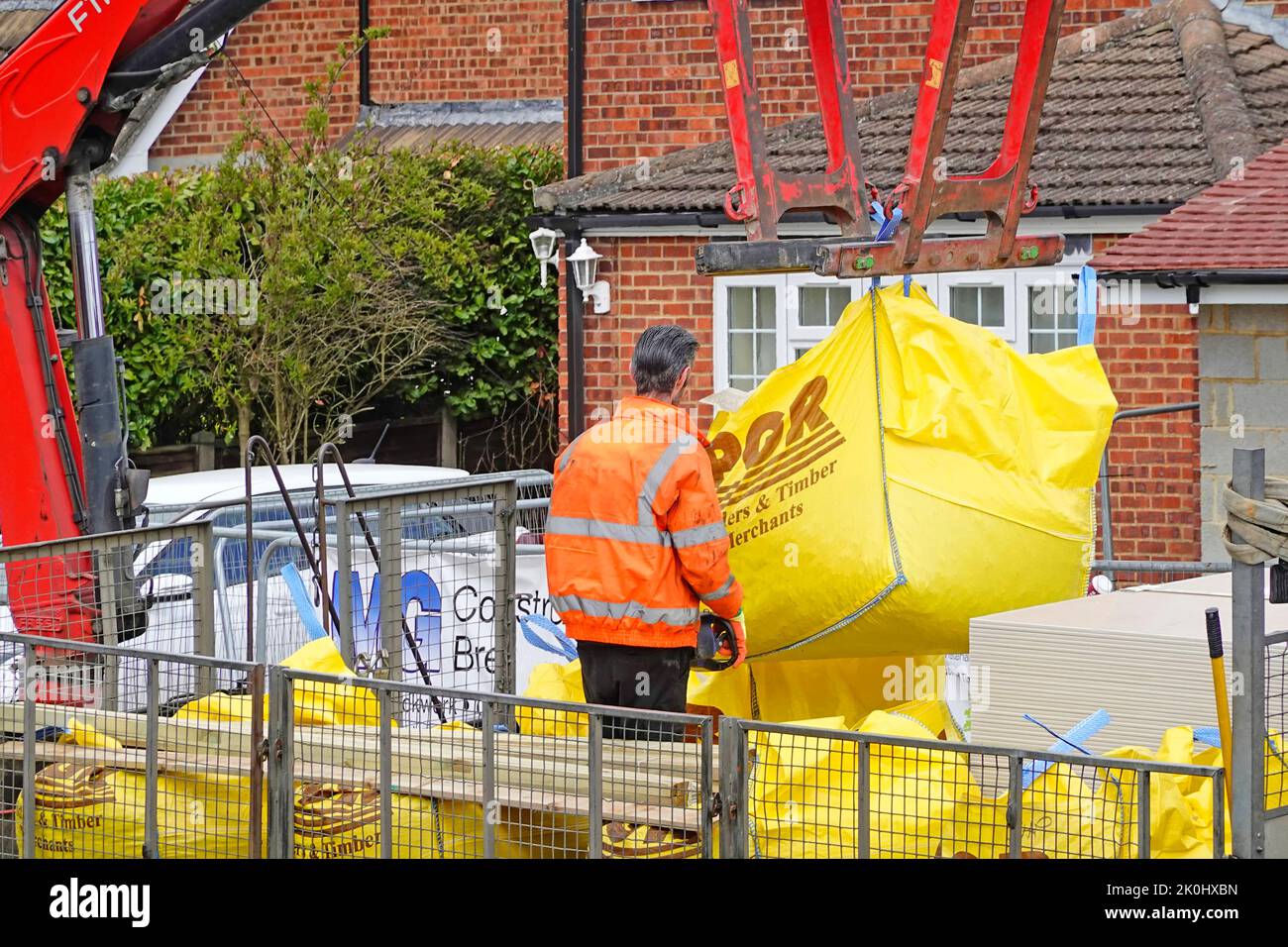 Nahaufnahme Bauherren Händler LKW montiert Hydraulikkran Rückseite der Lieferung Fahrer hebt Jumbo-Tasche Gebäude Baustellenmaterialien England Großbritannien Stockfoto