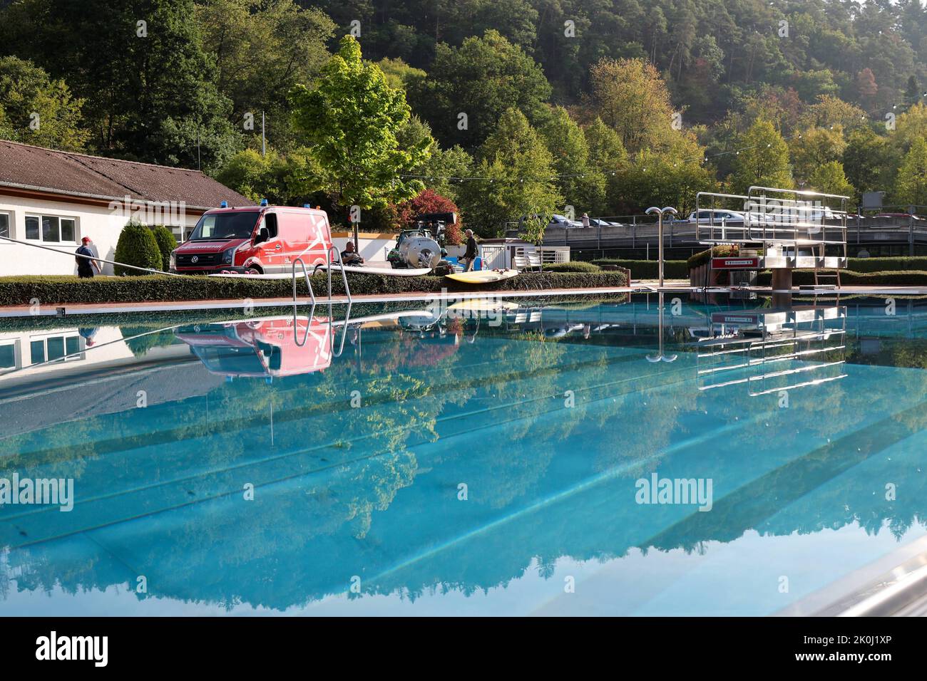 Bad Schwalbach, Deutschland. 12. September 2022. Benno Burggraf steht an  seinem Traktor mit Wasserbehälter und holt mit einer Pumpe Wasser aus dem  Becken von der Feuerwehr, um dann die Bäume im Kurpark