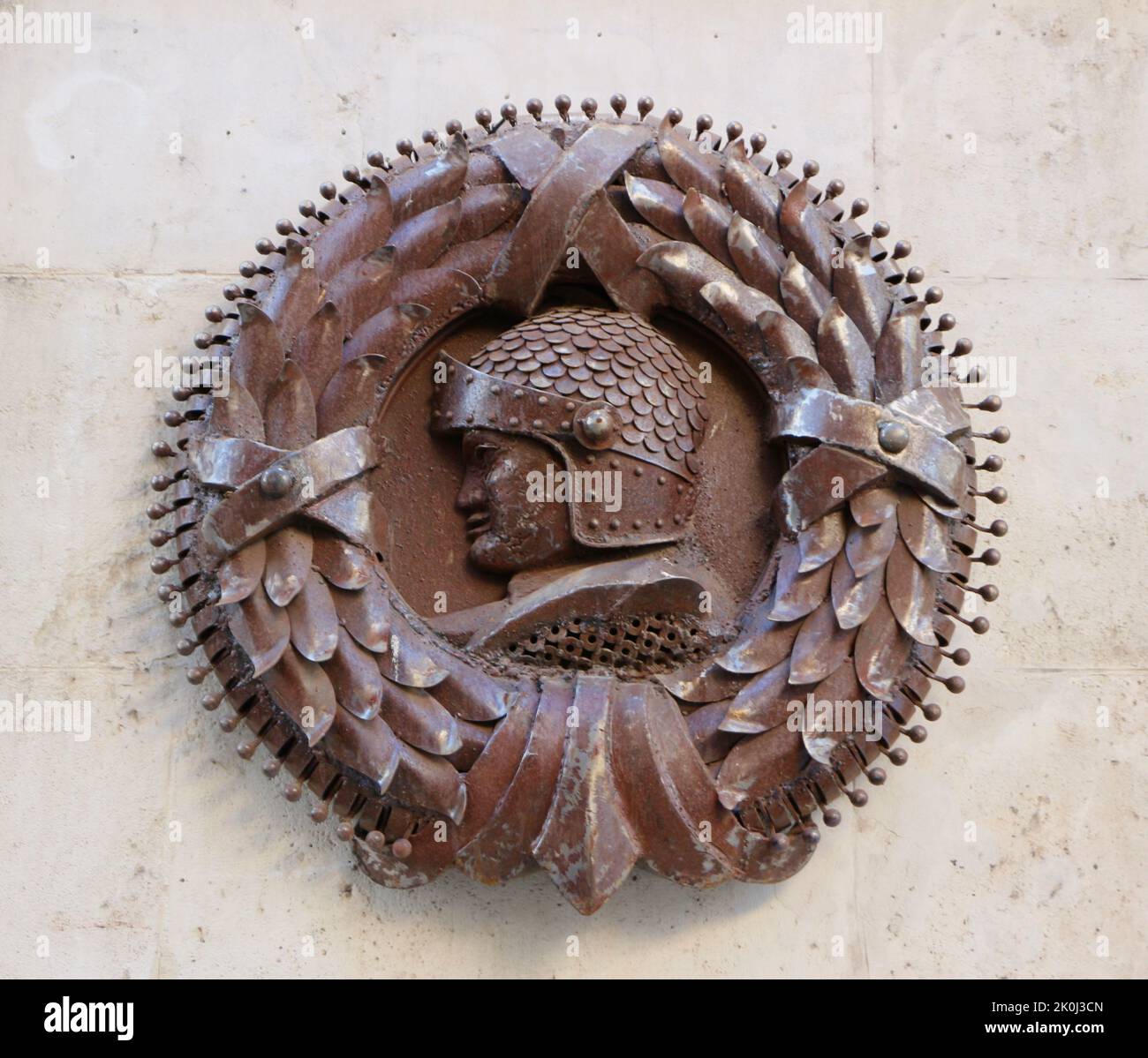 Braune, dreidimensionale, runde Wandtafel mit Lorbeerblättern und einem Ritter in Rüstung Stockfoto