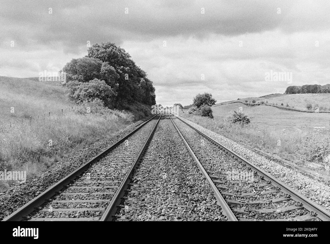 In Northumberland, Nordengland, ziehen sich Bahnstrecken in die Ferne, umgeben von einer offenen Landschaft. Gedreht auf 35mm Schwarzweißfilmen. Stockfoto