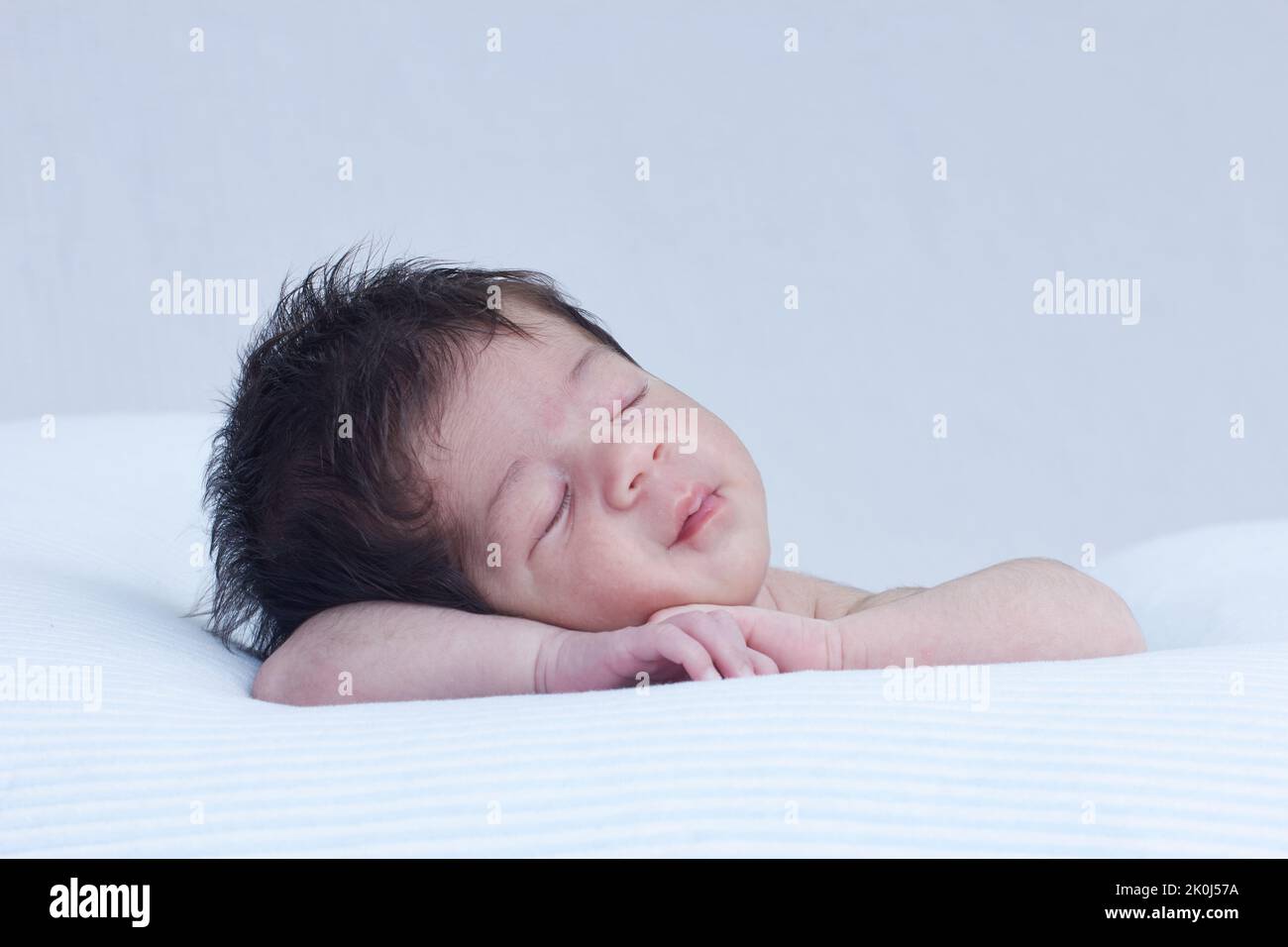 Baby Kleinkind schläft auf einem Kissen und ruht ihren Kopf auf ihren Armen in einer niedlichen Position Stockfoto