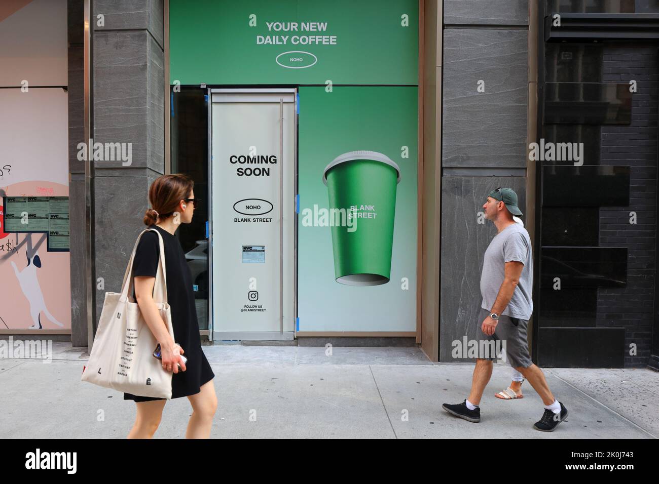 Menschen, die an einer halbautomatischen Coffee-Shop-Kette von Blank Street Coffee vorbeilaufen, die im New Yorker Stadtteil NoHo in Manhattan im Bau ist. Stockfoto