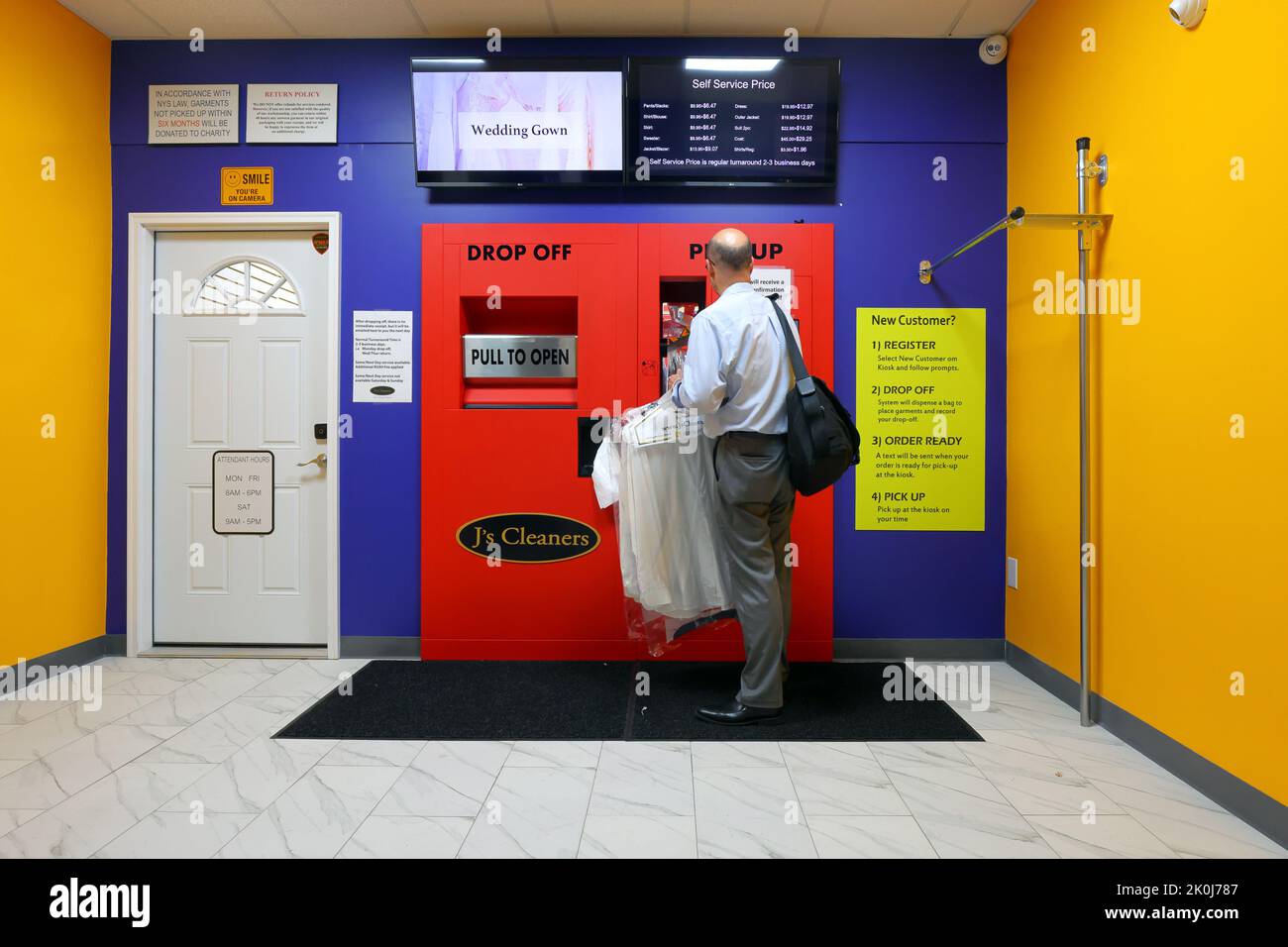 Eine Person, die einen 24hr-Zoll-Automaten für die automatische chemische Reinigung bei A J's Cleaners in New York, NY, verwendet. Stockfoto