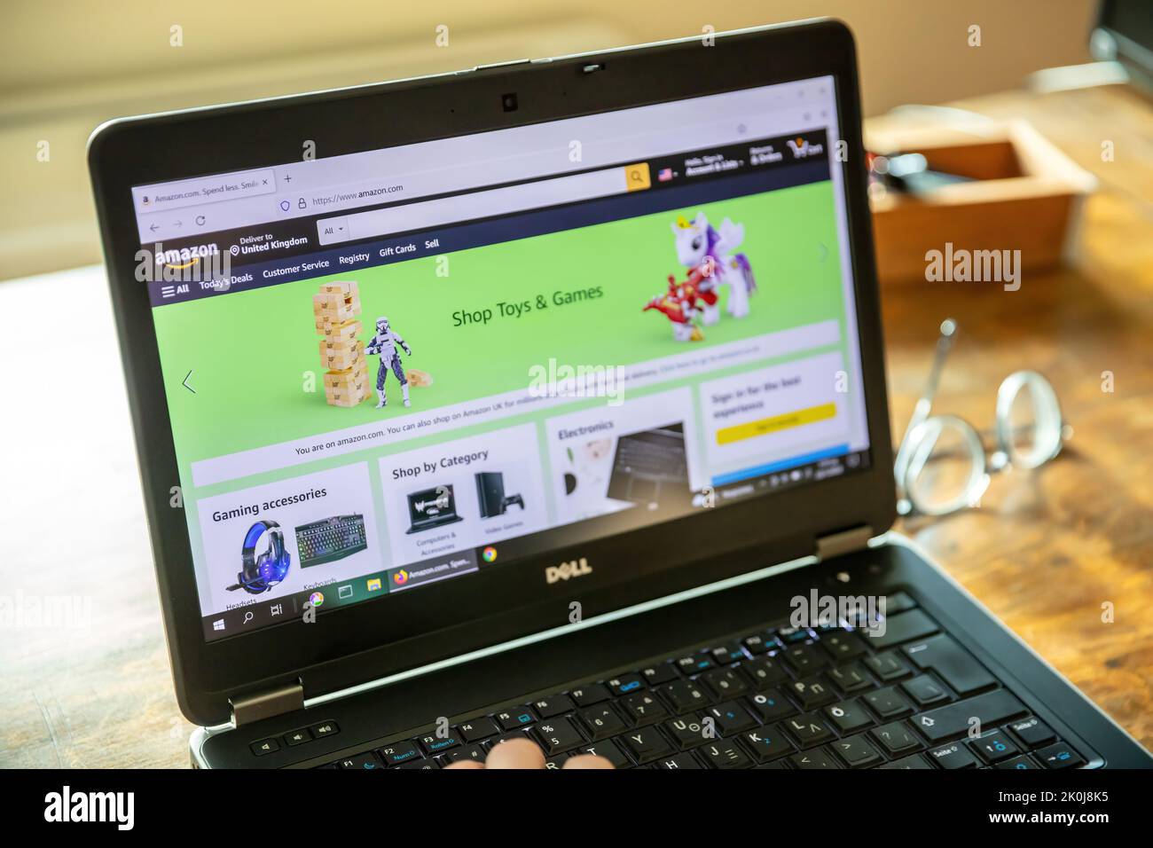 Griechenland, Athen, Januar 23 2022. AMAZON. com. App, Shop Spielzeug und Spiele, Amazon UK, Kundenservice. Notebook-Bildschirm auf unscharfer Büroschreibtisch, Hand Stockfoto