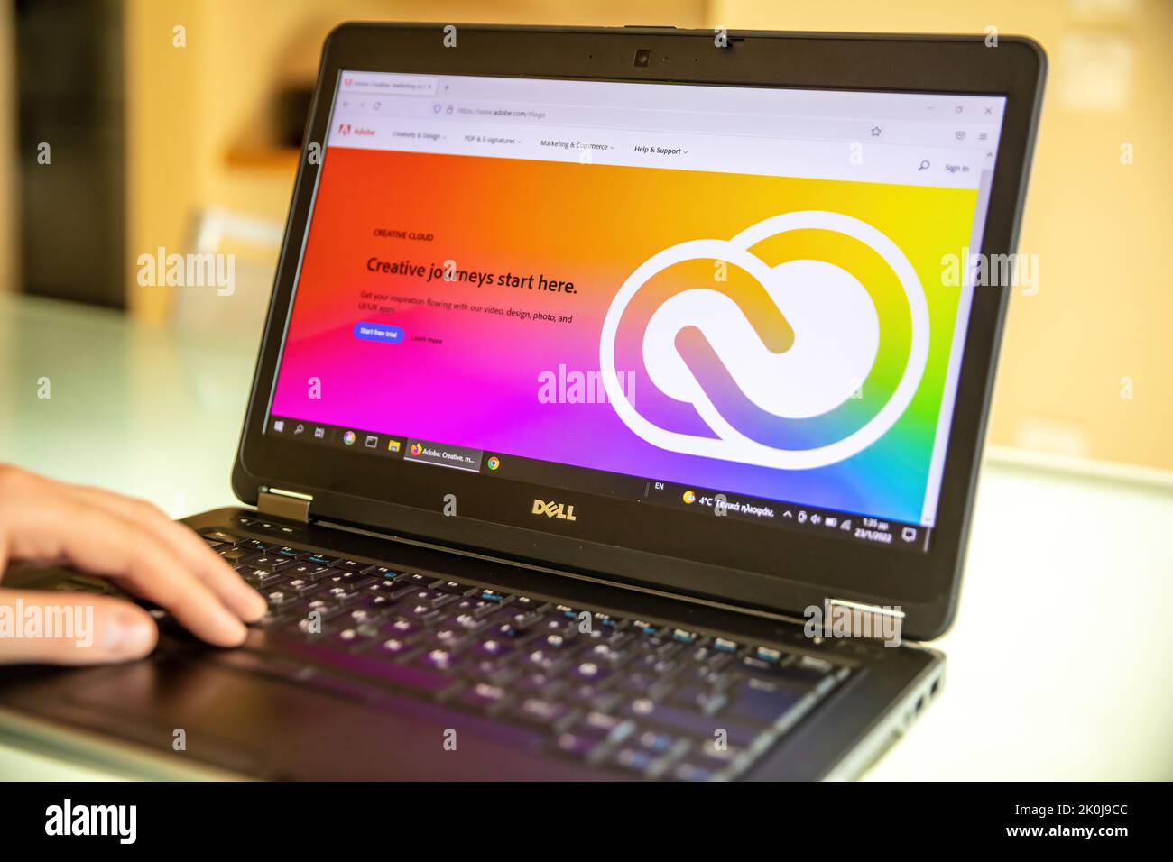 Griechenland, Athen, Januar 23 2022. ADOBE-App. Unternehmenslogo für Creative Apps and Services auf dem Laptop-Bildschirm, verwackelte Büroschreibtische, Hand auf der Tastatur. Stockfoto