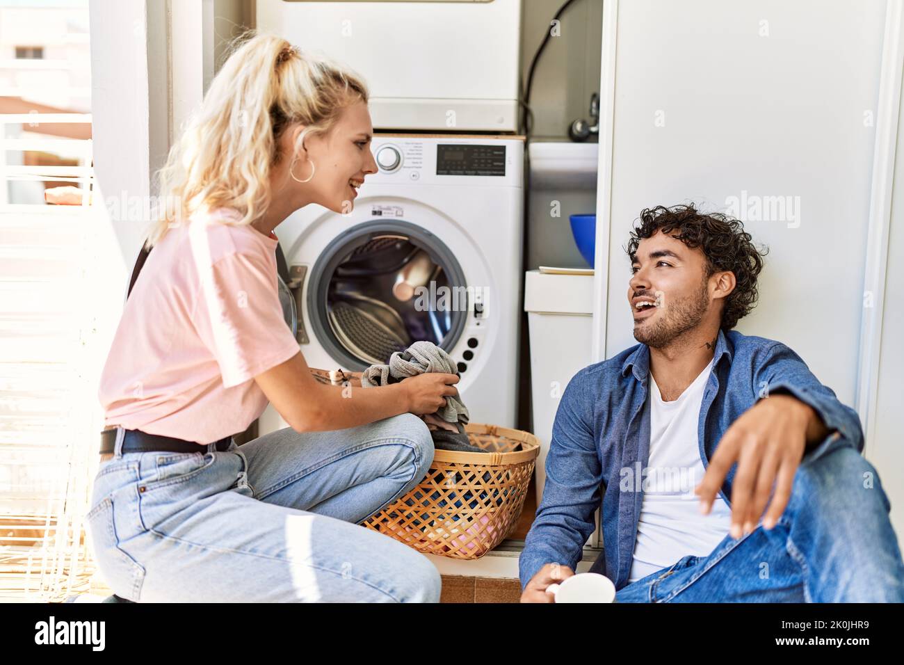 Junges Paar lächelt glücklich Kaffee trinken, während die Wäsche zu Hause. Stockfoto