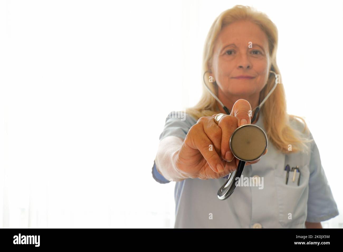 Die Krankenschwester zeigt einen weißen Stethoskop-Hintergrund Stockfoto