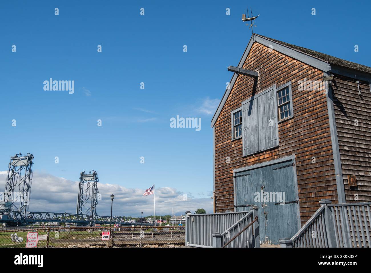 Portsmouth, NH, USA, 7. September 2022: Das historische Sheafe Warehouse im Prescott Park mit der modernen Memorial Bridge im Hintergrund. Stockfoto