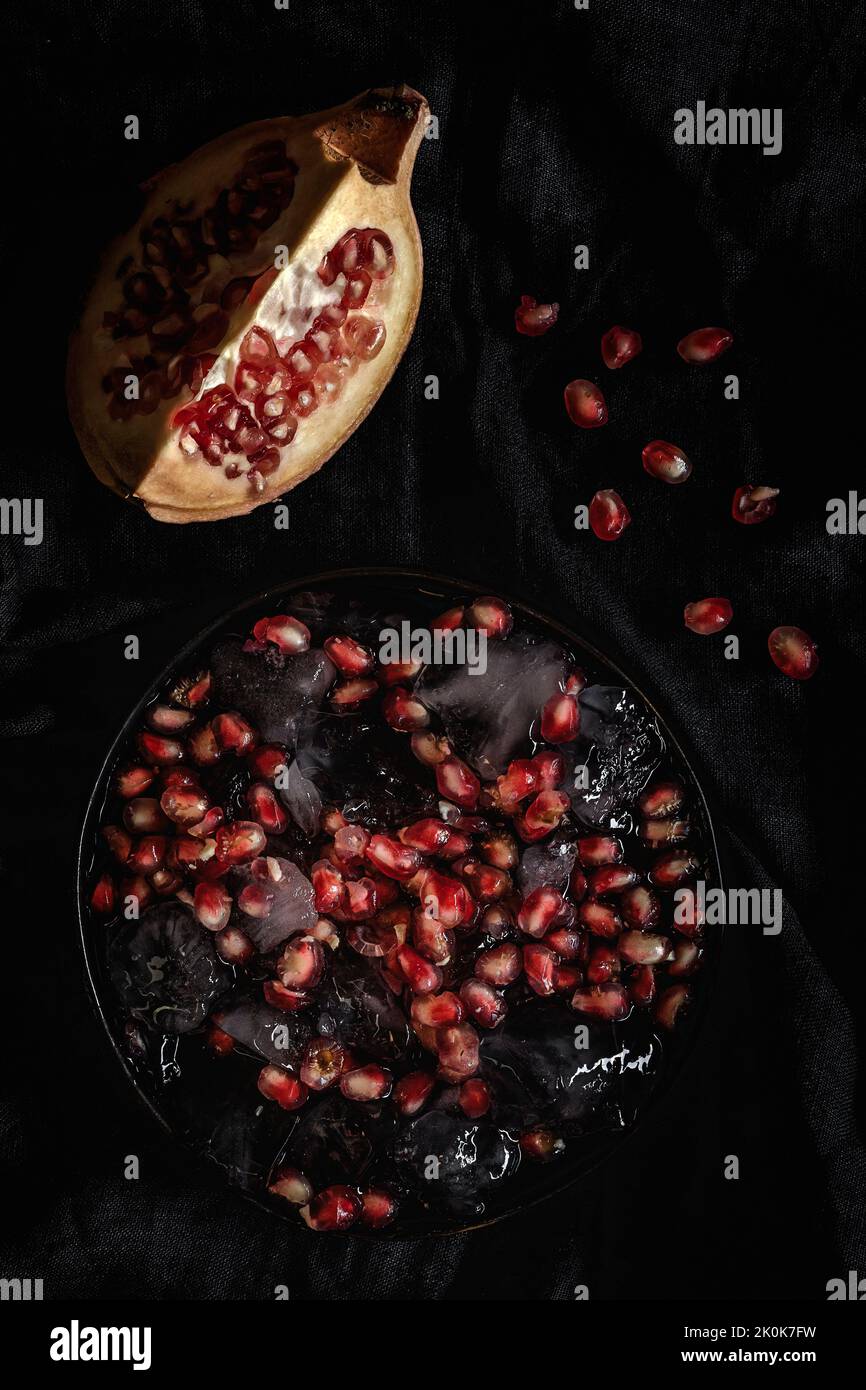 Frischer und roter Granatapfel auf dunklem Grund. Früchte der Herbstsaison. Oberer Flay, Draufsicht Stockfoto