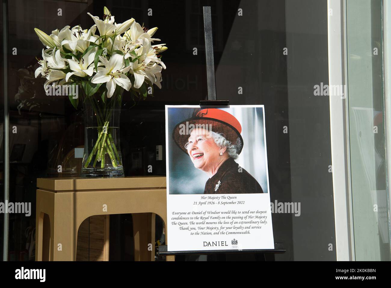 Wunderschöne Lilien und eine Hommage an Ihre Majestät die Königin im Fenster des Daniel-Departements in Windsor. Der Daniel Store ist Inhaber eines Royal Warrant. Quelle: Maureen McLean/Alamy Live News Stockfoto