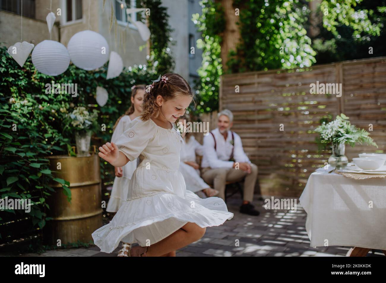 Kleines Kind tanzt und genießt draußen Hochzeitsfeier ihrer Eltern. Stockfoto