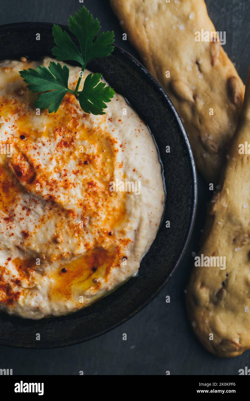 Leckerer Hummus mit Paprika, Olivenöl und etwas Brot zum Eintauchen Stockfoto