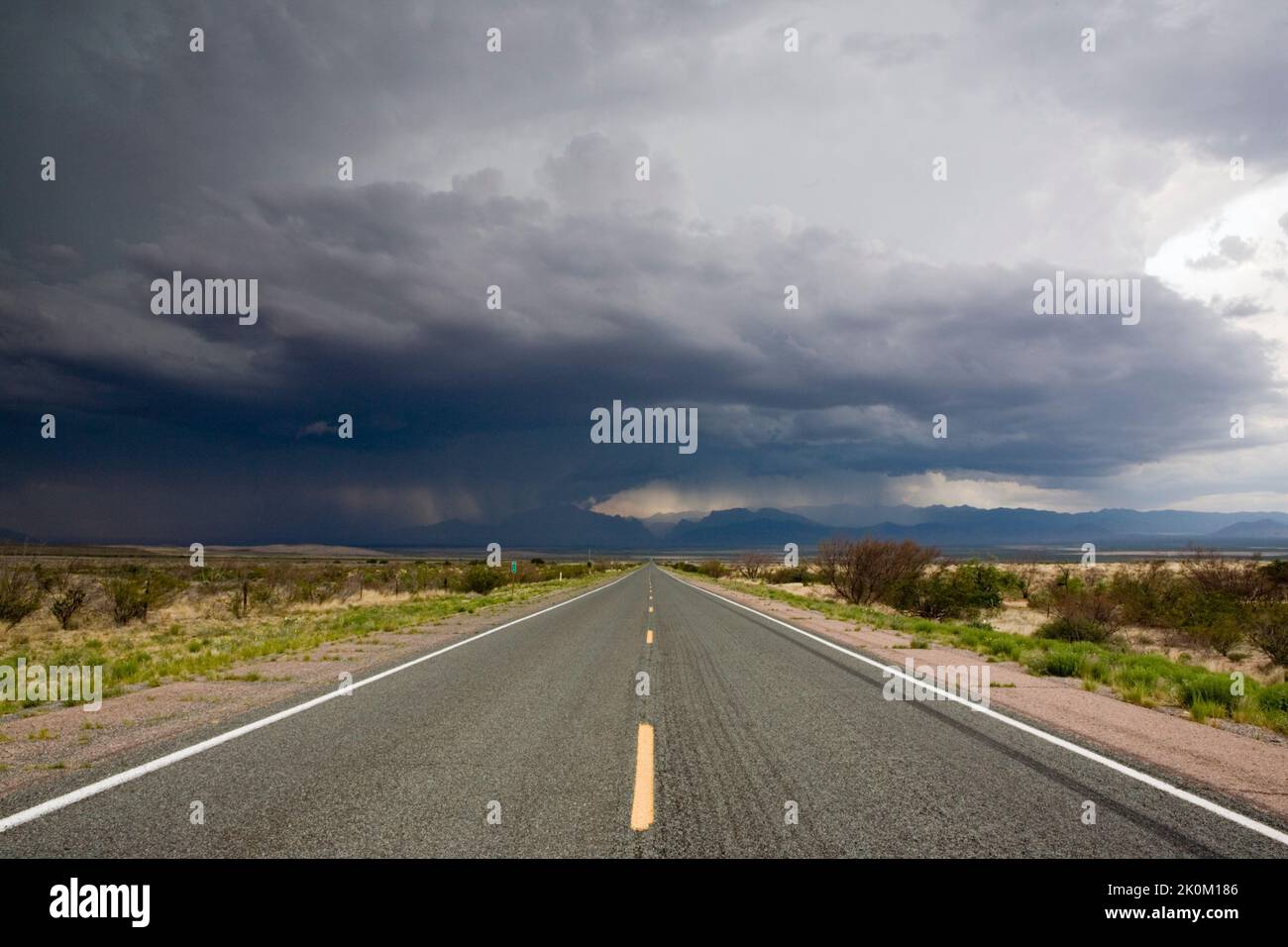 Heftige Gewitter über dem verlassenen Highway durch die Wüste bei Rodeo, New Mexico, USA Stockfoto