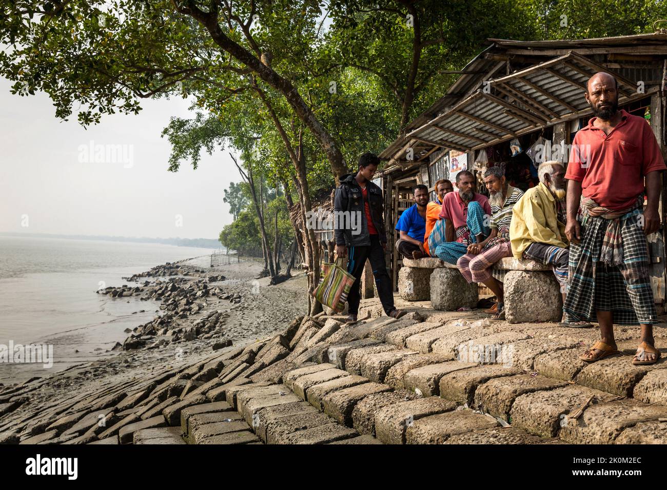 Sreetlife in Shyamnagar. Die Menschen in den kleinen Siedlungen entlang der Flüsse im Süden Bangladeschs spüren deutlich die Auswirkungen des Klimawandels. Der Meeresspiegel steigt und Dämme werden zerstört. Dadurch werden Felder und wichtige Süßwasserteiche überflutet und salzt. Daher werden große Anstrengungen unternommen, um die Banken zu stärken. Auch Wohngebäude werden angehoben und befestigt. Suesswater-Ernteprojekte sind sehr wichtig, um Menschen mit sauberem Trinkwasser zu versorgen. Stockfoto