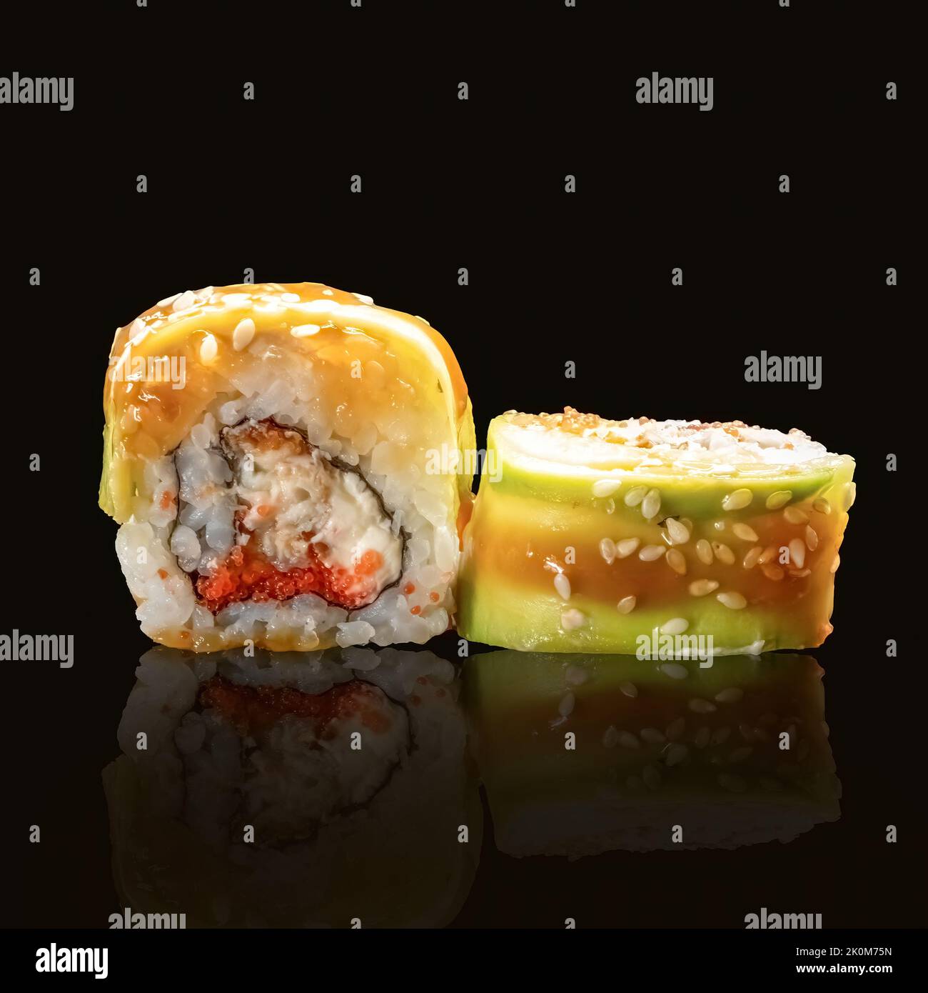 Nahaufnahme von Maki-Sushi-Rollen im japanischen Stil auf schwarzem Hintergrund. Sushi-Rolle mit Lachs, Tofu, Gemüse und Avocado-Nahaufnahme. Stockfoto