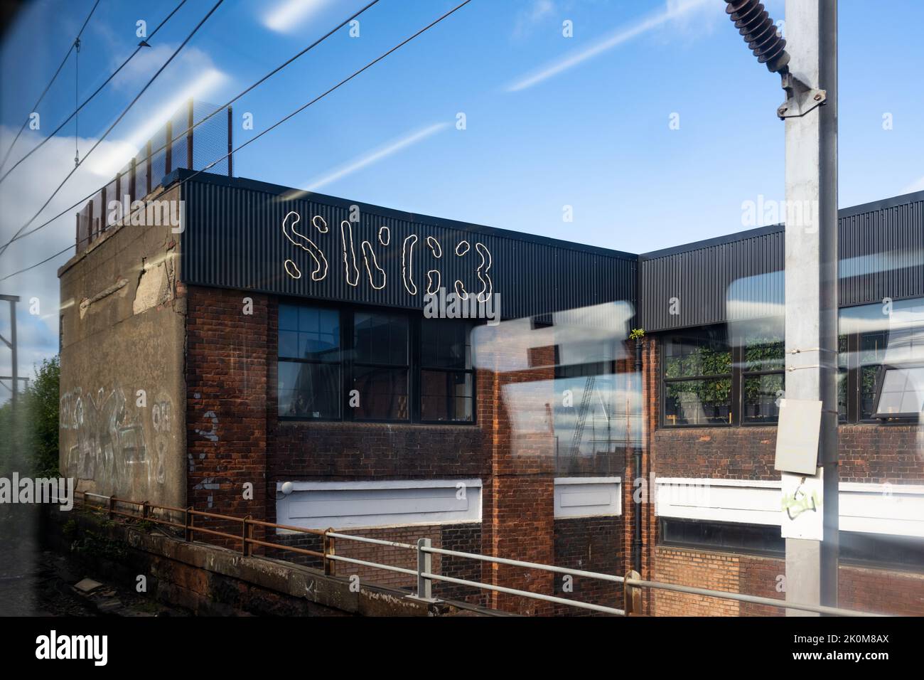 SWG3 Studio Warehouse vom vorbeifahrenden Zug aus gesehen - Kunstraum im westlichen Ende von Glasgow, Schottland, Großbritannien Stockfoto