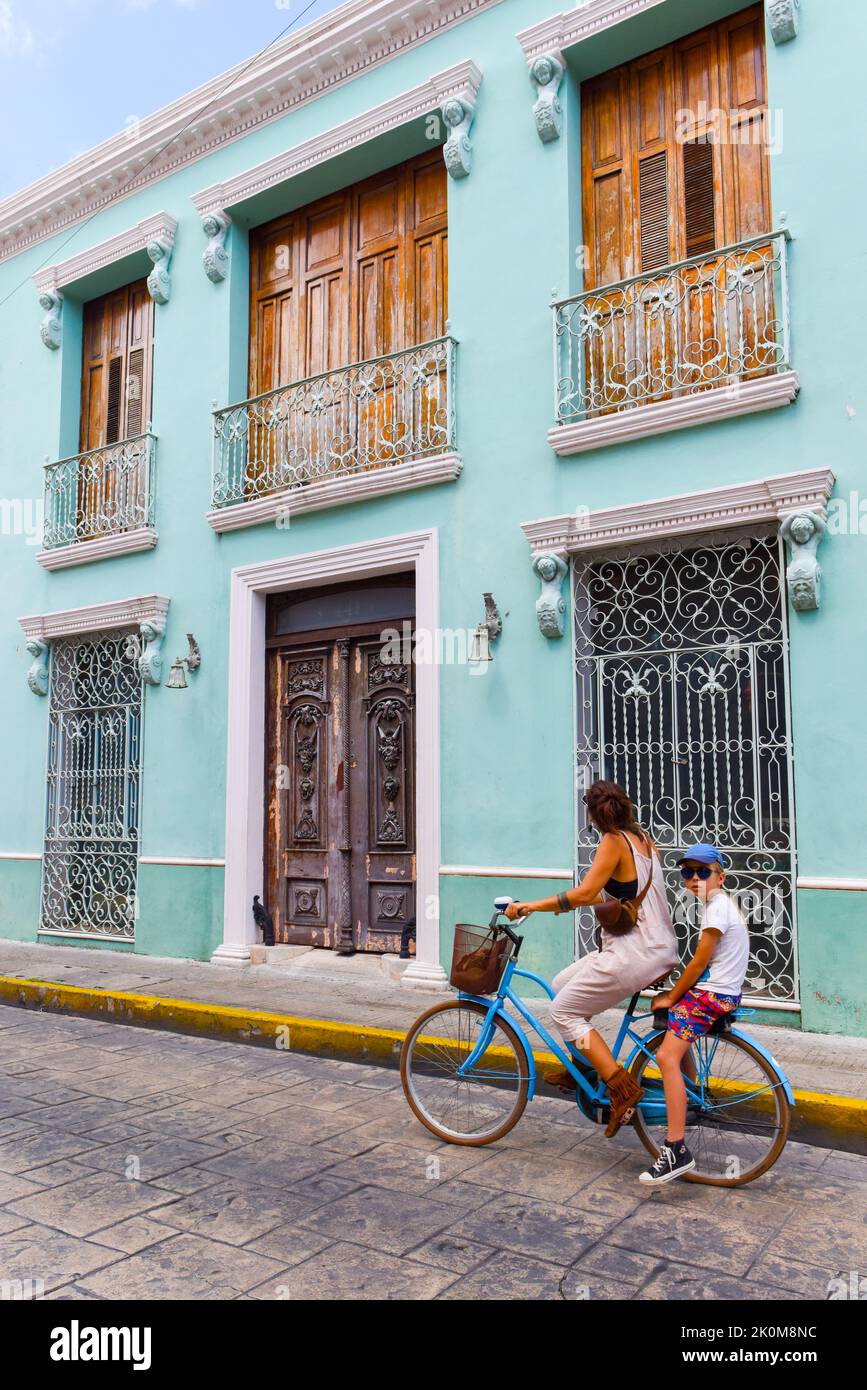 Radfahrer fahren vor einem Kolonialgebäude, Merida Mexiko Stockfoto