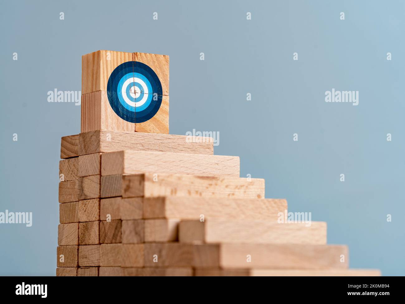 Kllose up Foto von Leiter aus Holzblöcken und Ziel-Zeichen auf der Oberseite als Symbol des Kletterns oder hart arbeiten für Ziele und Ziele. Stockfoto