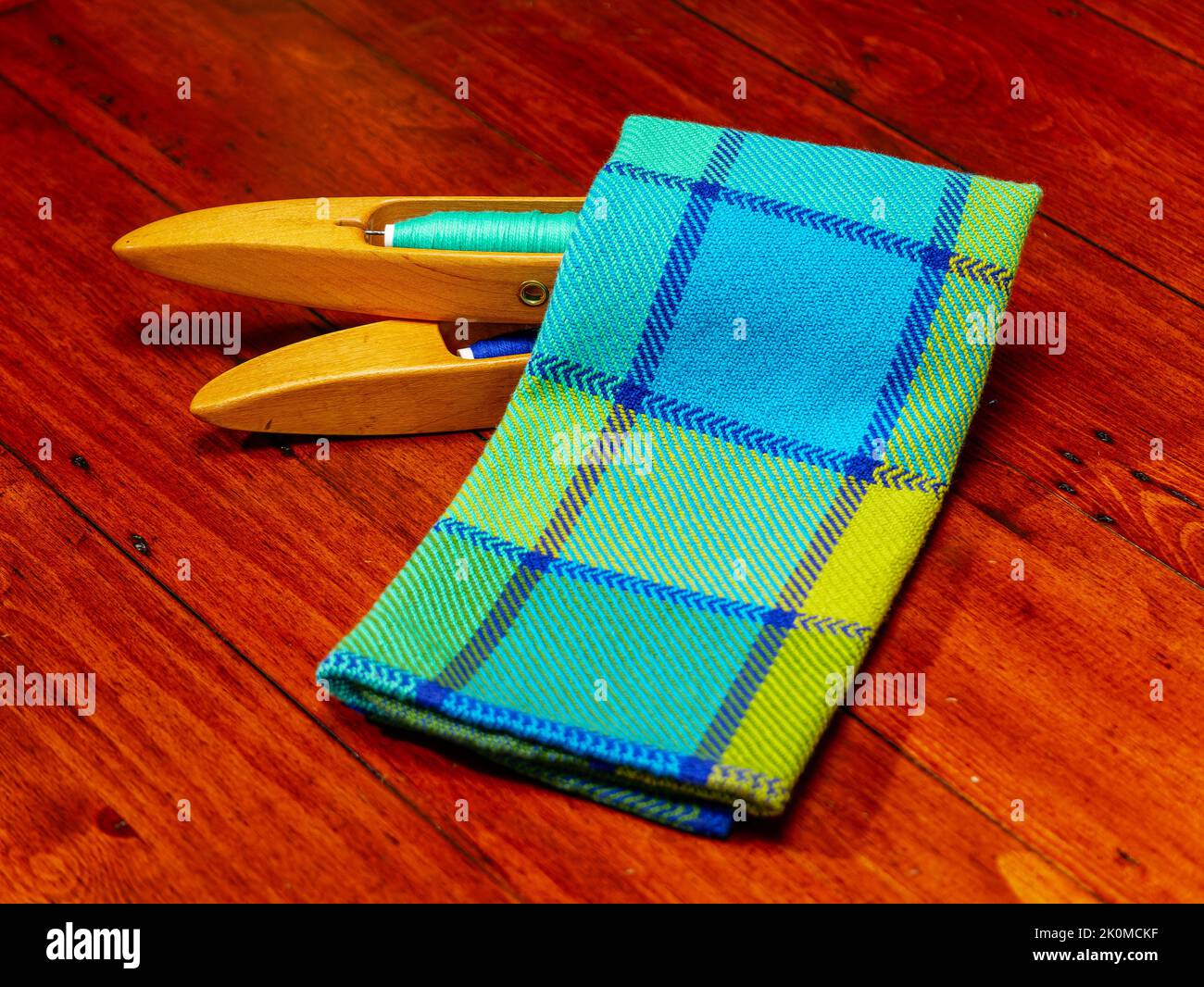 Ein gewebtes Textil und ein Paar Webstuhl-Shuttles mit Faden geladen Stockfoto