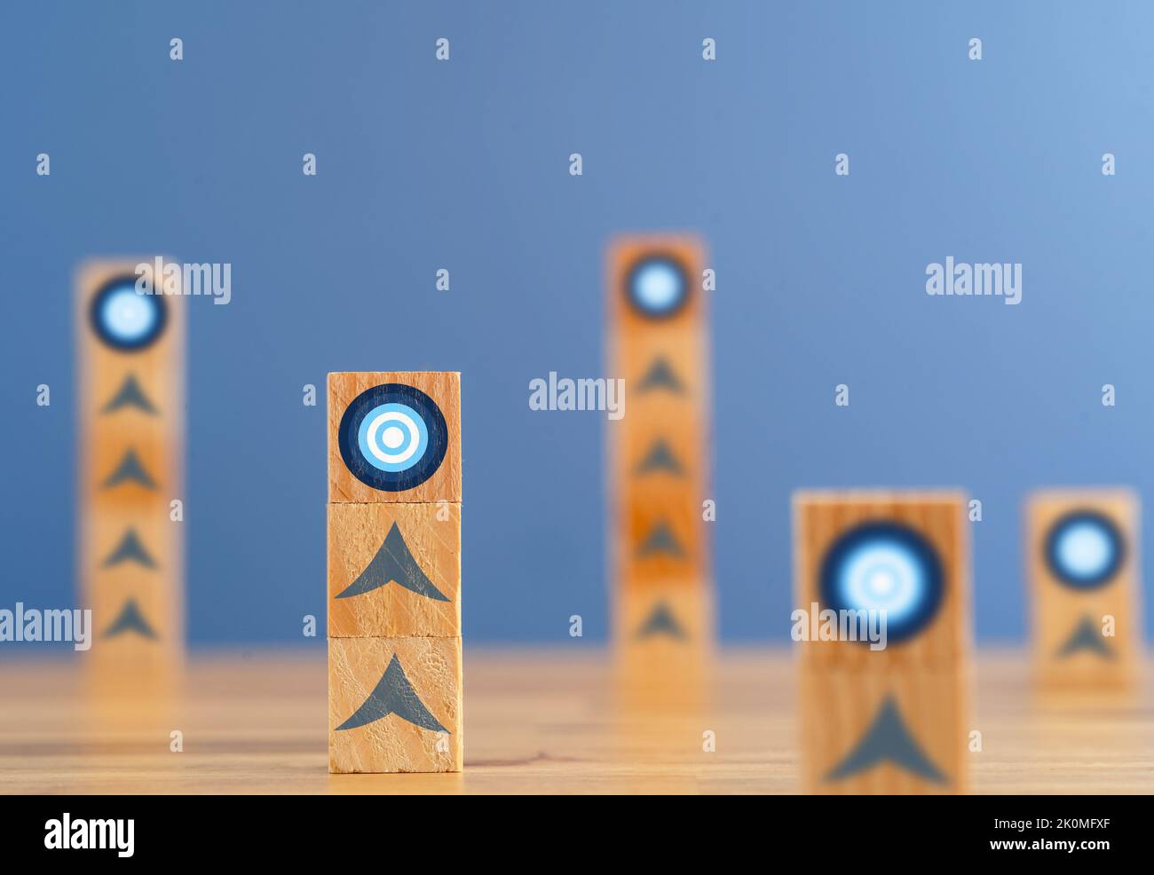 Nahaufnahme von gestapelten Holzblöcken mit Zielsymbol als Symbol für das Einrichten neuer Ziele und das Erreichen von Zielen. Stockfoto