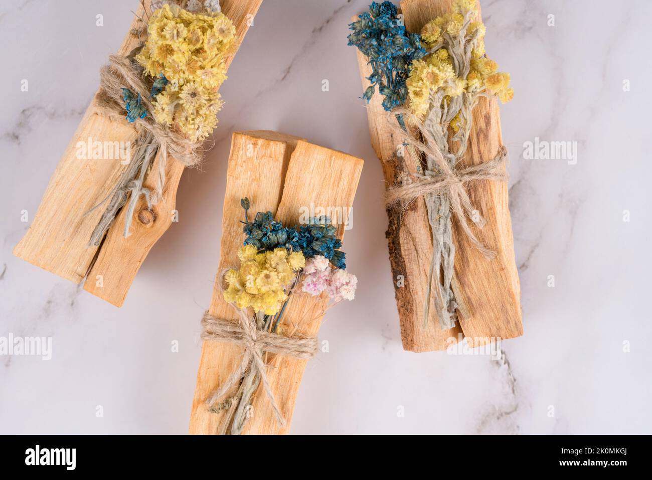 Verschmieren mit palo santo-Stäbchen, verziert mit trockenen aromatischen Kräutern auf weißem Marmortisch. Raumbegasungsritual für Yoga und Meditation p Stockfoto