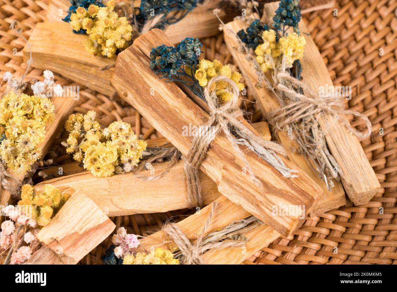 Verschmieren mit palo santo. Viele palo santo-Sticks mit trockenen aromatischen Kräutern auf Strohschale dekoriert. Raumbegasungsritual für Yoga und Meditationsprakt Stockfoto