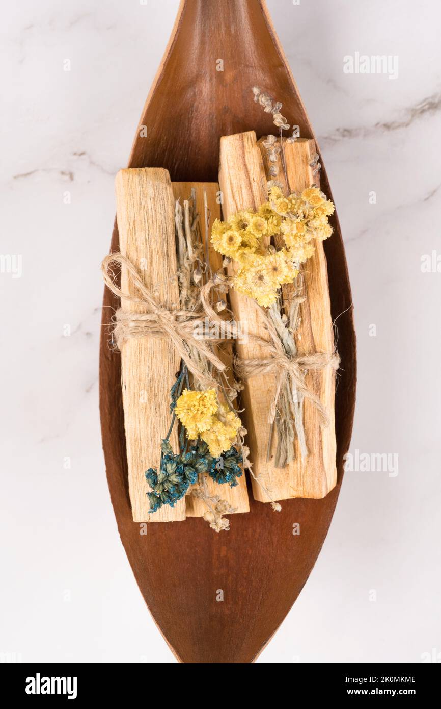 Verschmieren mit palo santo-Stäbchen, verziert mit trockenen aromatischen Kräutern. Raumbegasungsritual für Yoga und Meditationspraktiken. Vertikale Zusammensetzung Stockfoto