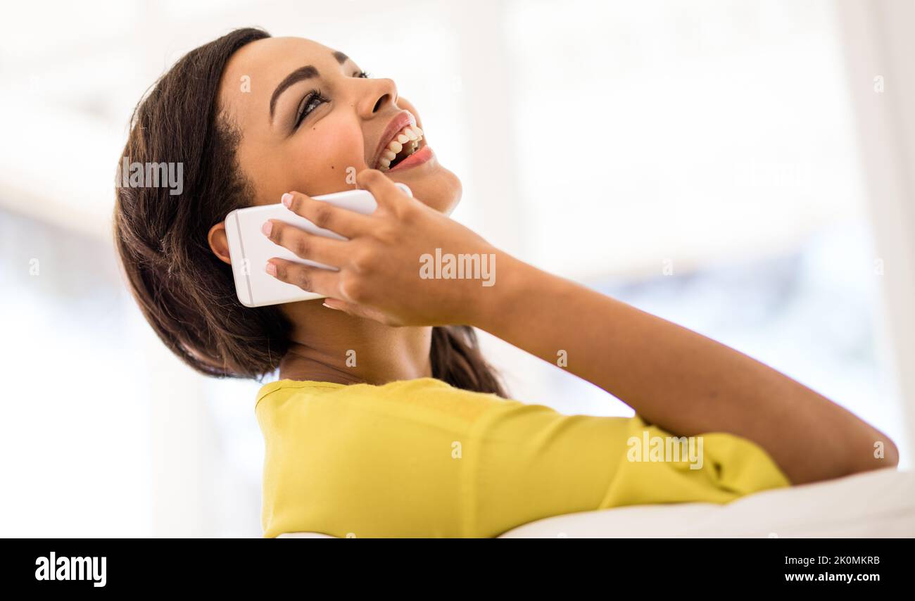 Im Gespräch mit einer guten Freundin. Eine junge Frau, die zu Hause auf ihrem Handy spricht. Stockfoto