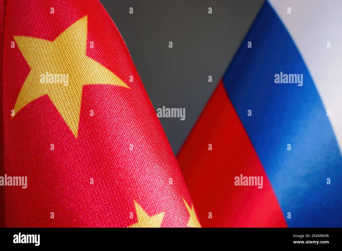 Nahaufnahme der chinesischen und russischen Flaggen als Symbol der Zusammenarbeit. Stockfoto