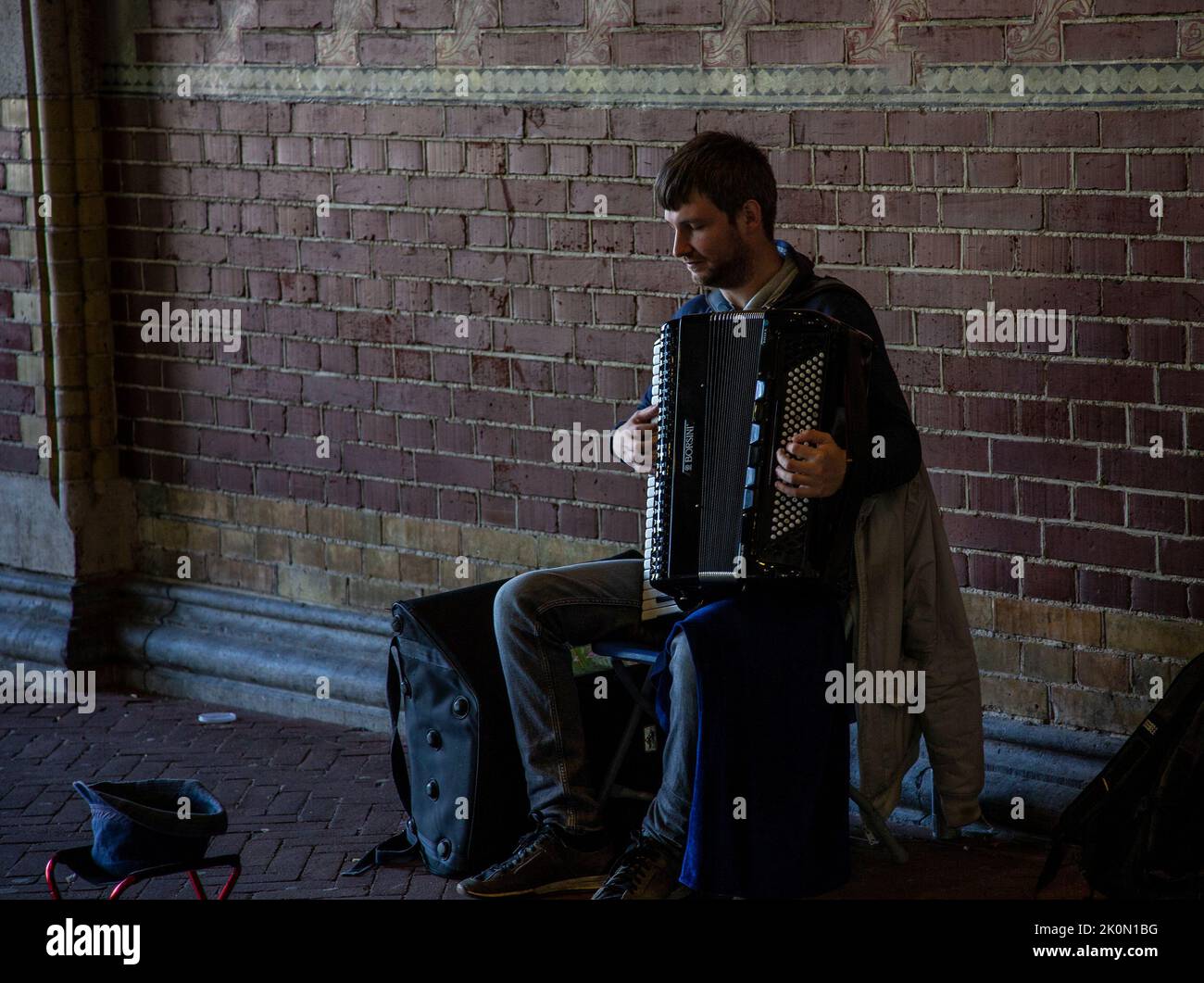 Straßenmusiker spielt Akkordeon in einer Amsterdamer Unterführung Stockfoto